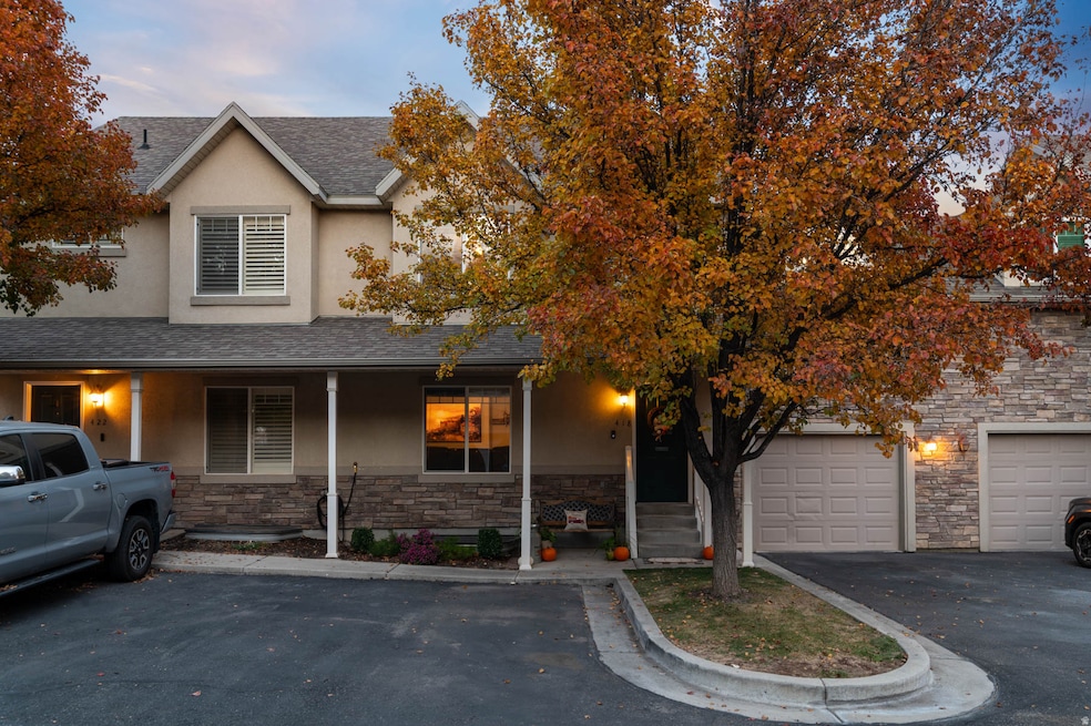 View of front of home featuring covered porch, stone siding, stucco siding, and a shingled roof