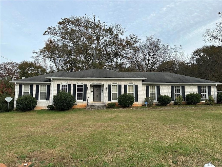 Ranch-style home featuring a front lawn