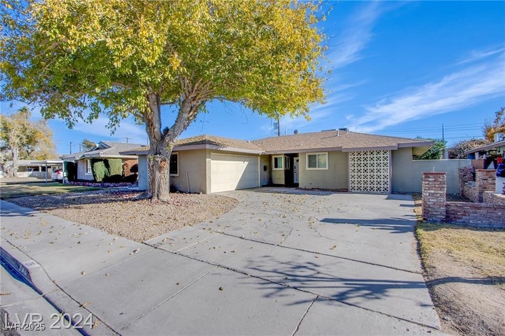 Ranch-style home with concrete driveway, an attach