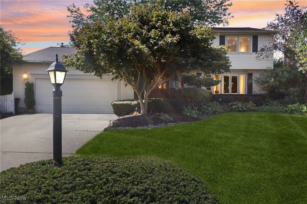 View of front of house with driveway, a yard, and a garage