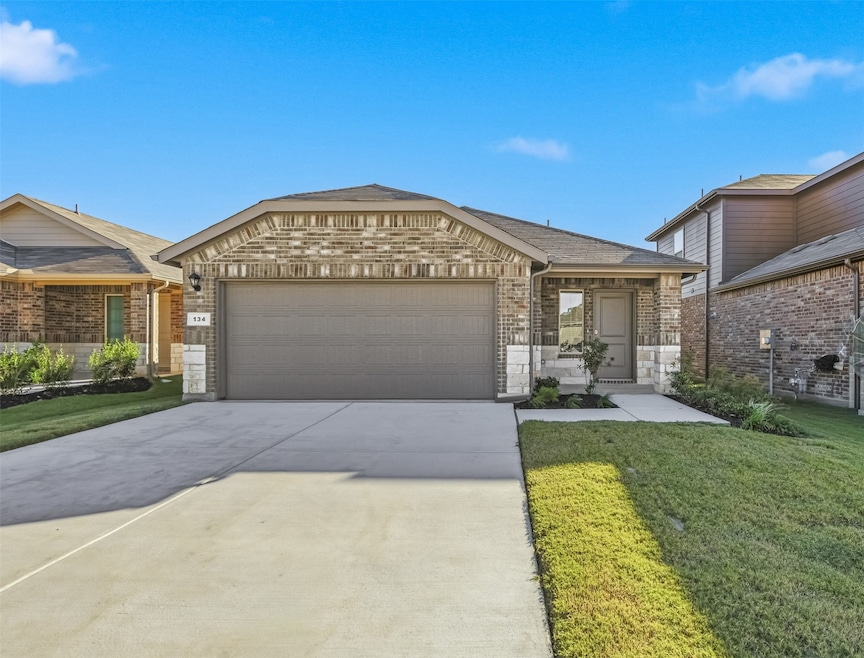 Ranch-style home with brick siding, concrete driveway, a front lawn, and an attached garage