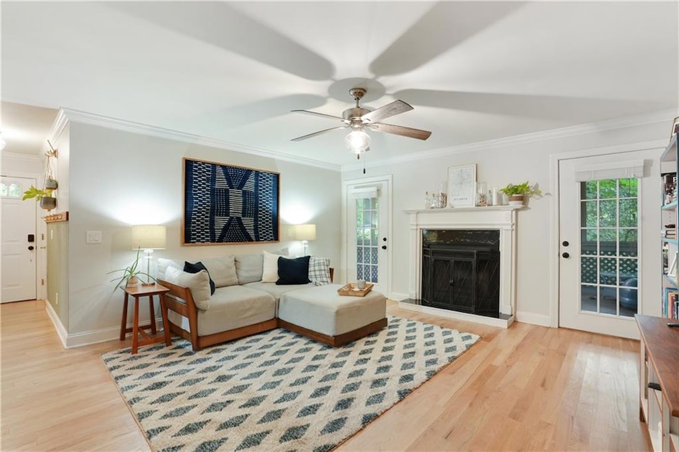 Living area featuring ceiling fan, crown molding, wood finished floors, and baseboards