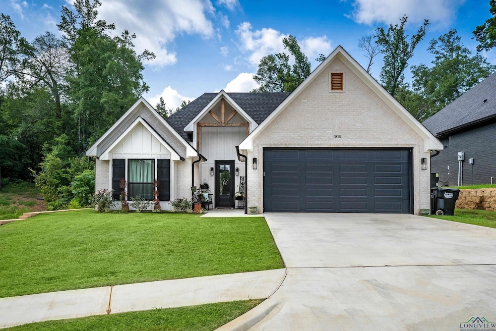 Modern farmhouse with concrete driveway, a front lawn, a garage, board and batten siding, and brick siding