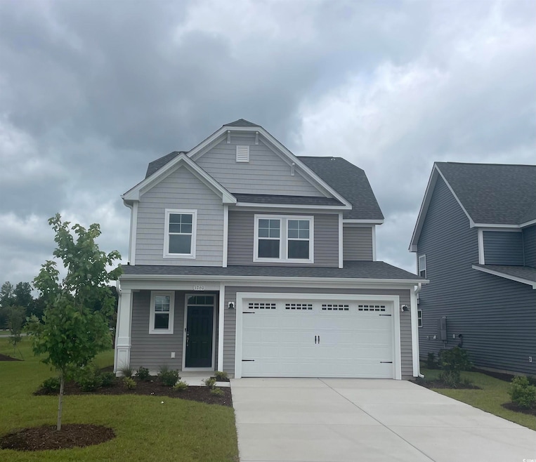 View of front facade with driveway, a front yard, a garage, and roof with shingles