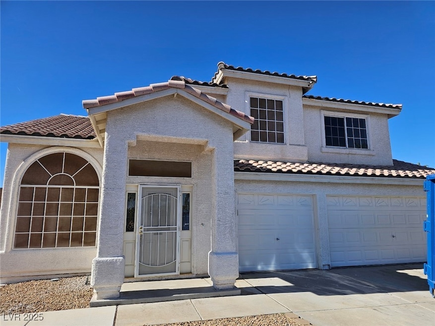 Mediterranean / spanish-style house featuring a tile roof, stucco siding, an attached garage, and driveway