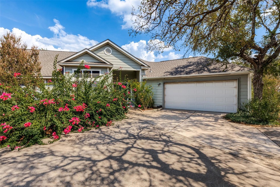 View of front of house with a shingled roof, concrete driveway, and an attached garage