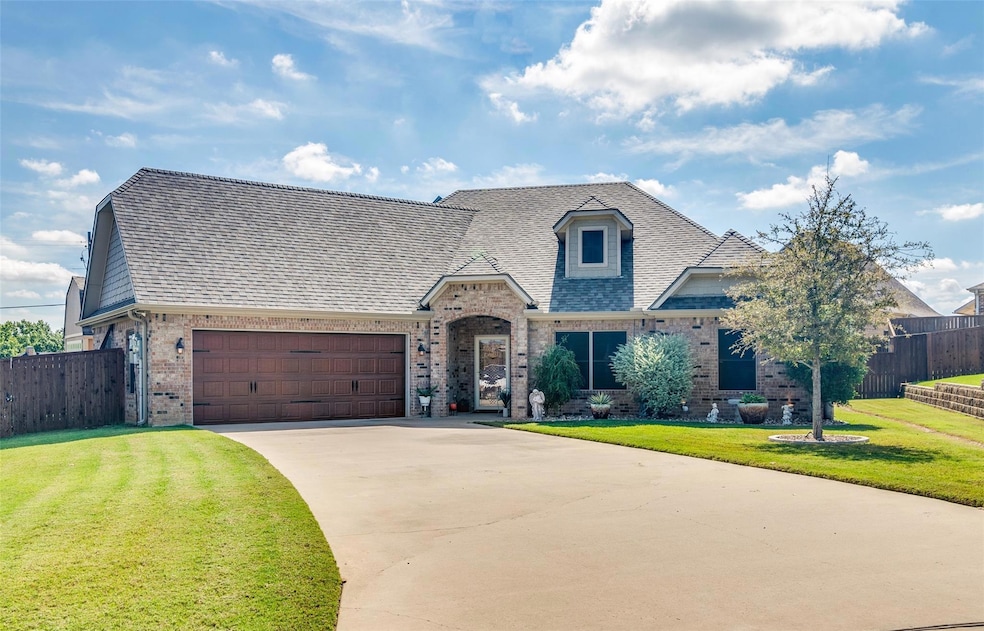 View of front of property with a front yard and a garage