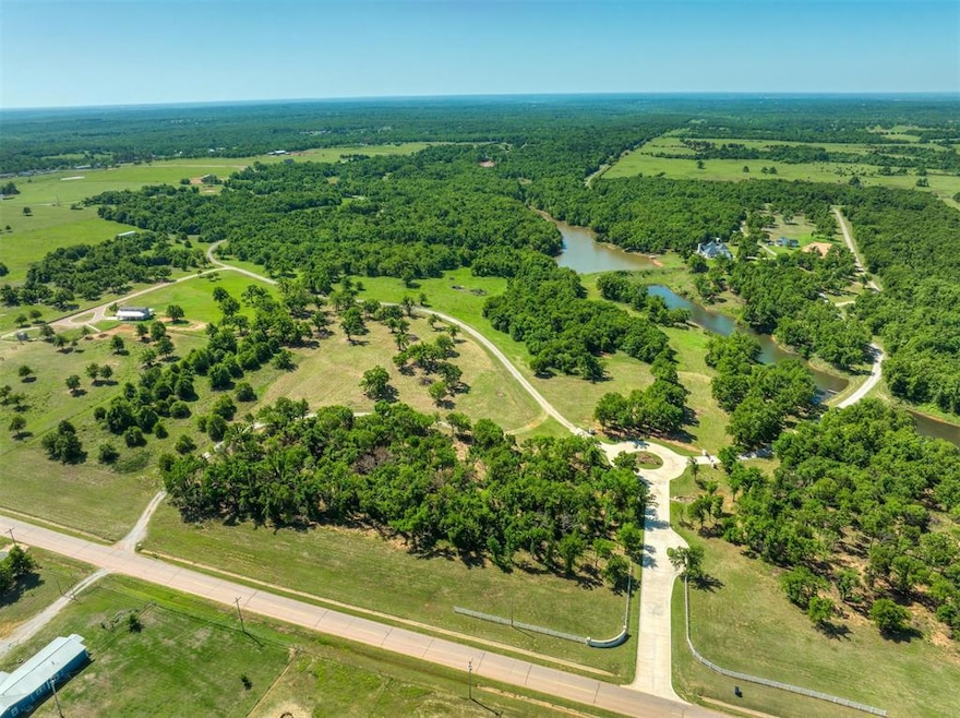 Birds eye view of property featuring a water view and a wooded view