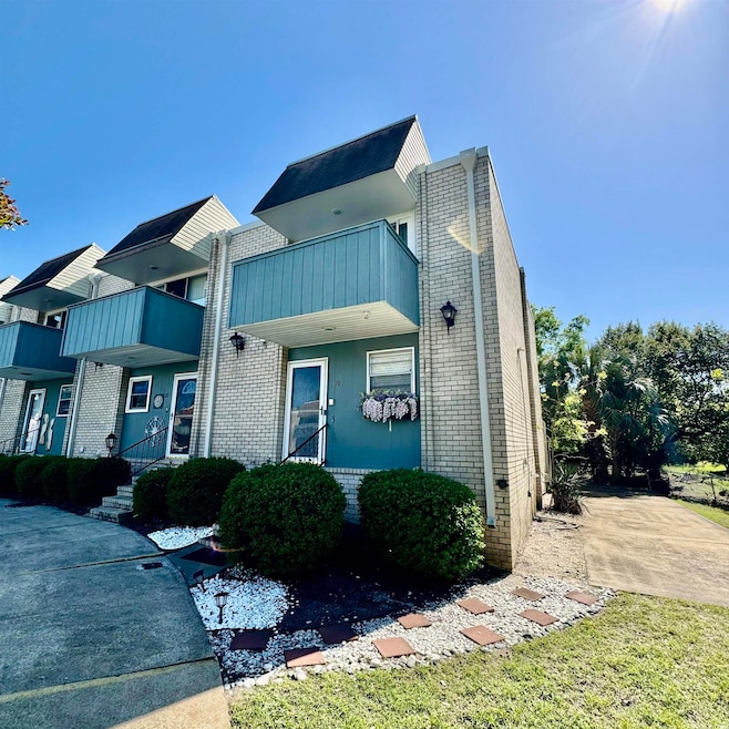 View of front of home featuring a balcony and bric