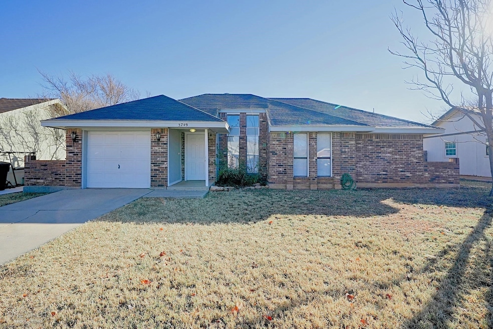 Ranch-style home with a garage and a front lawn