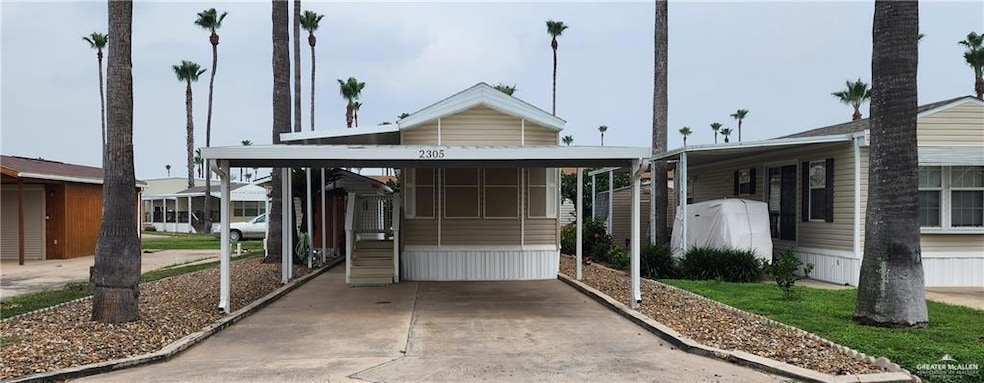 View of front of property featuring an attached carport and concrete driveway