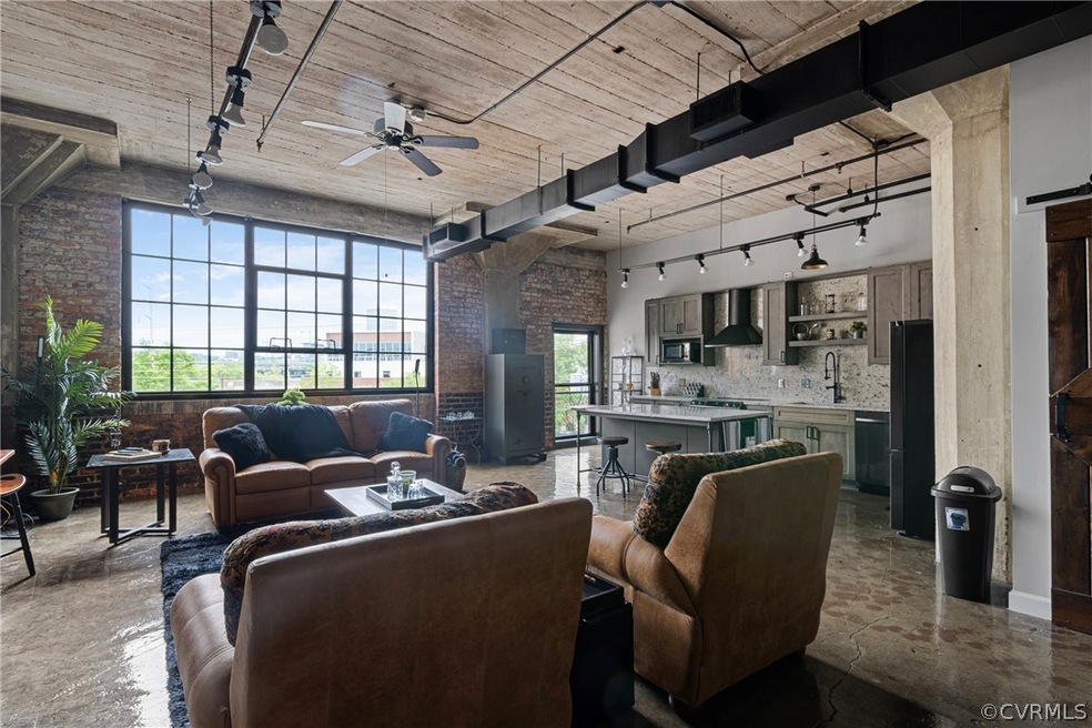 Living room featuring brick wall, plenty of natura