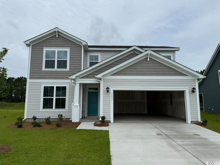 View of front of house with concrete driveway, a front lawn, and an attached garage