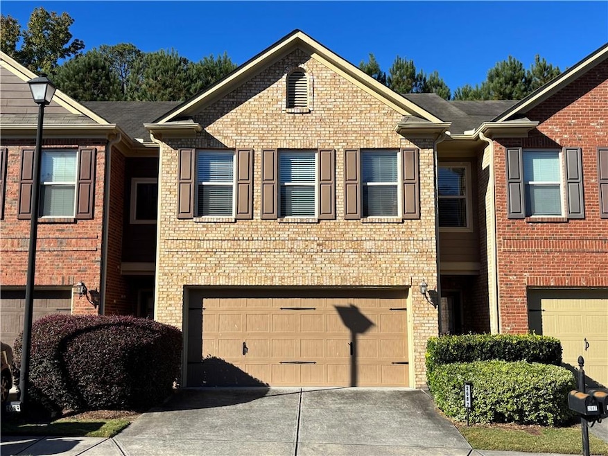 View of front facade featuring concrete driveway, brick siding, and an attached garage