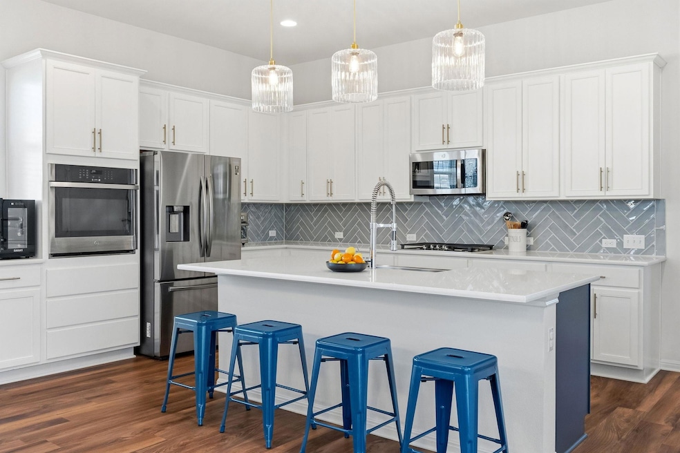 The bright kitchen boasts gleaming granite counters, abundant storage and stainless steel appliances.