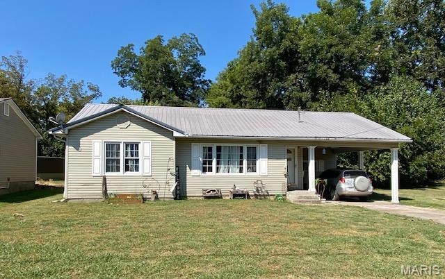 Single story home featuring a front yard, driveway, a metal roof, an attached carport, and covered porch