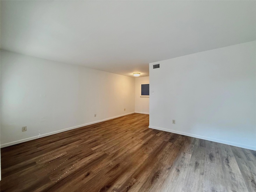 Unfurnished room featuring dark wood-style floori