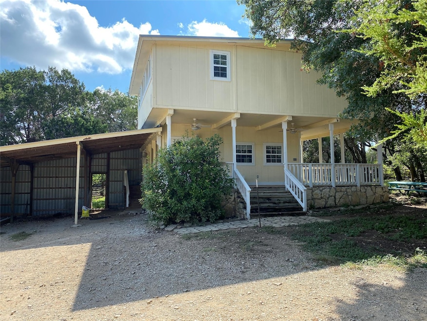 View of front of property featuring a carport, a ceiling fan, covered porch, and driveway