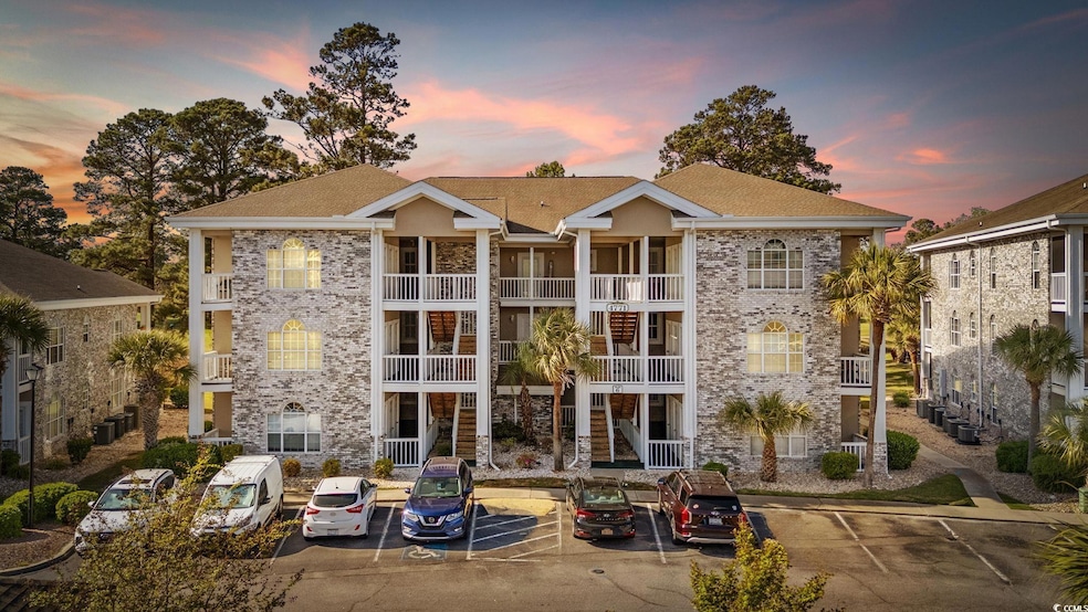 View of building exterior with uncovered parking
