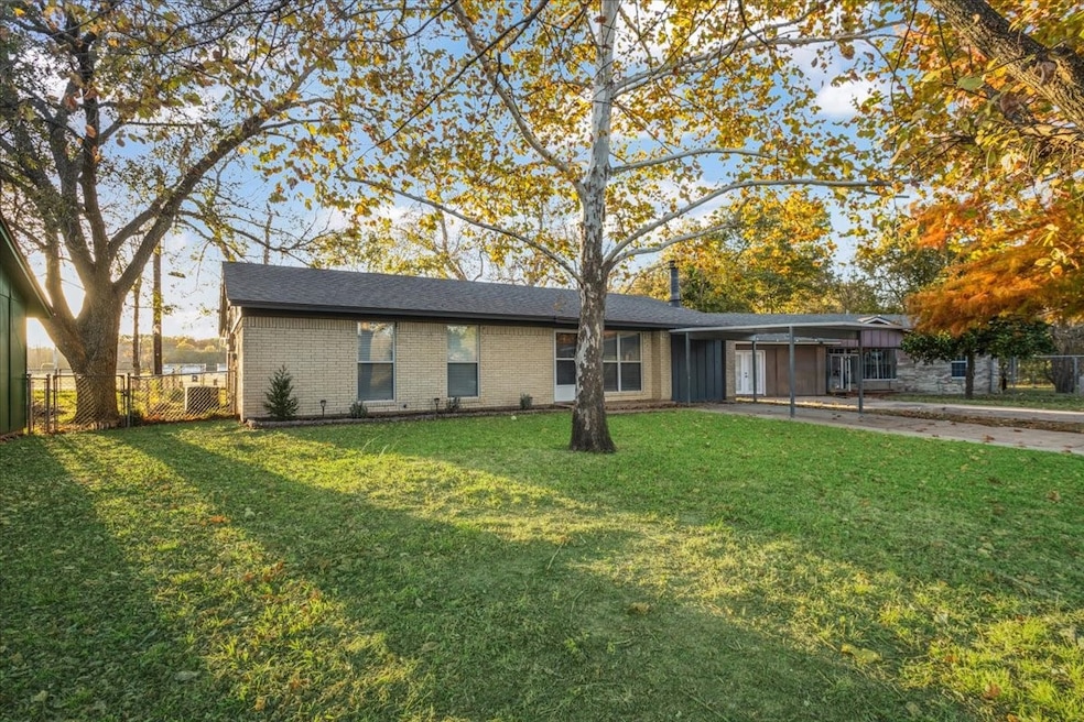 View of front of house featuring a carport, brick siding, and driveway