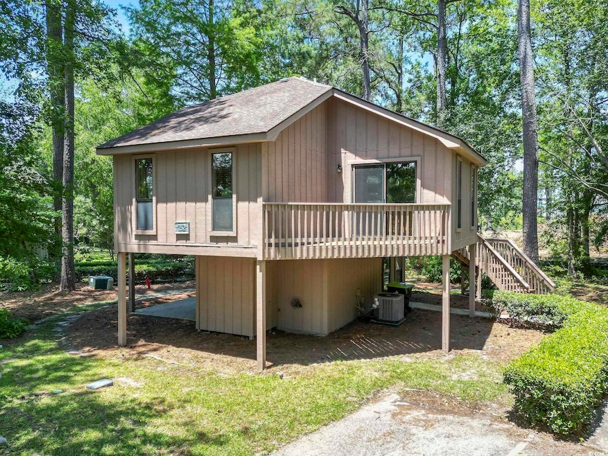 View of front of home featuring cooling unit, stairs, a shingled roof, and a wooden deck