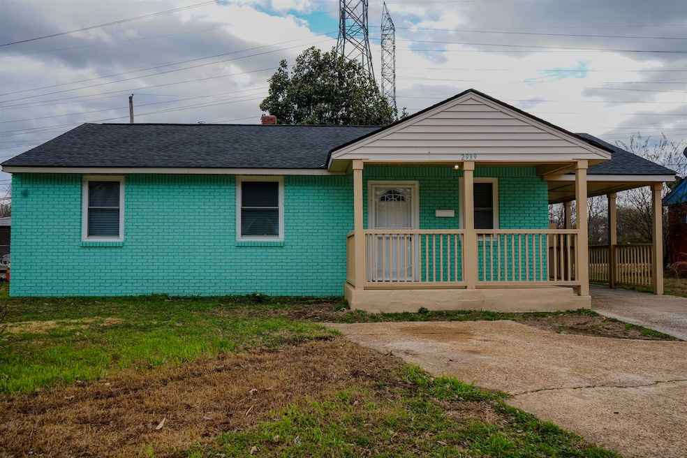 View of front of property with a porch, roof with shingles, brick siding, and a front yard