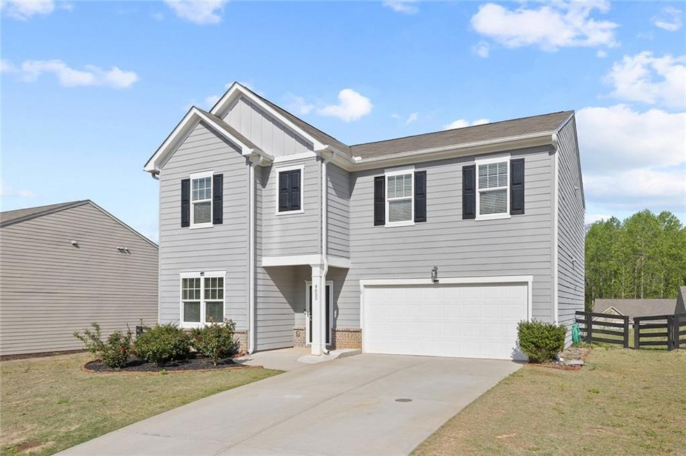 View of front of property with a garage, board and batten siding, and concrete driveway