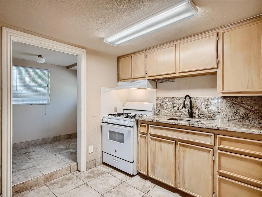 Kitchen with a sink, gas range gas stove, under c