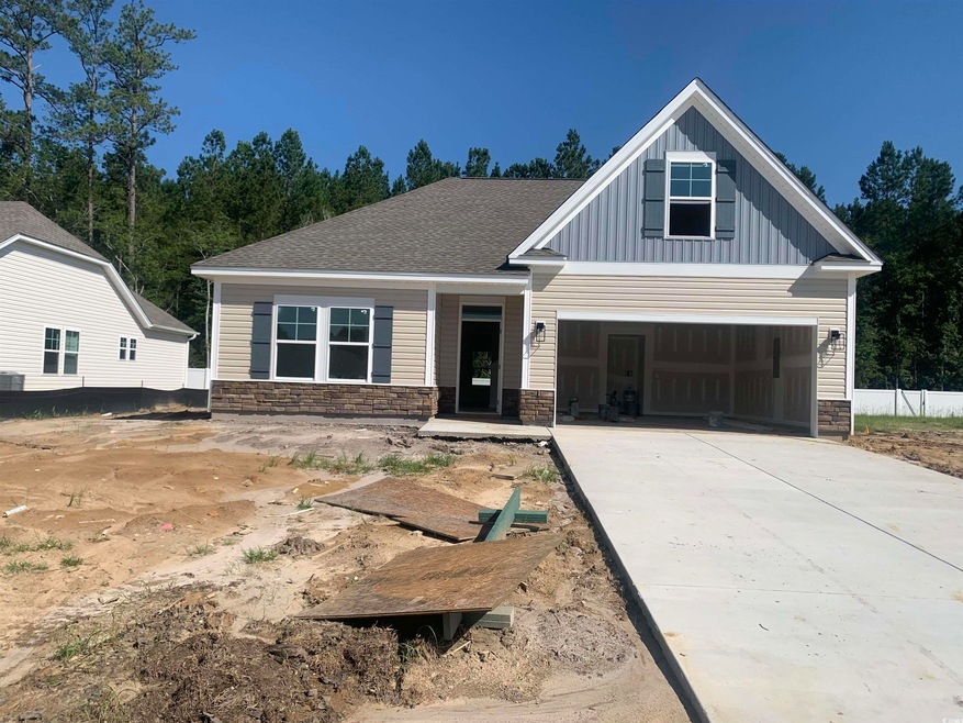View of front of home with stone siding, board and batten siding, and concrete driveway