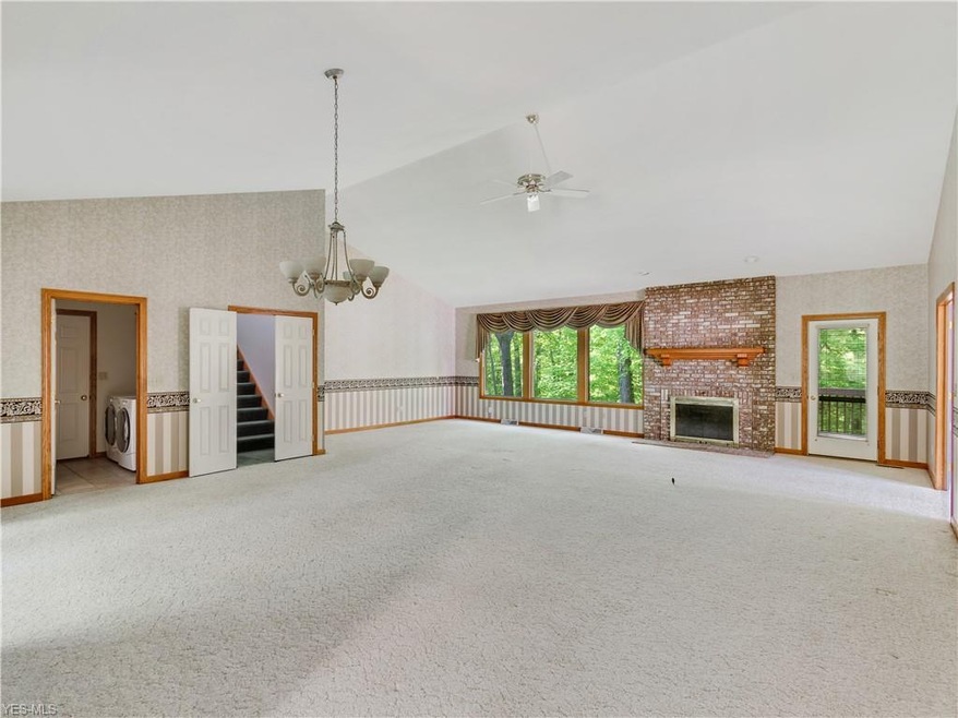 Enjoy the open living area with vaulted ceilings and great windows looking out into the woods.