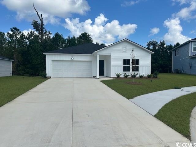 View of front of home with a front lawn and a gara