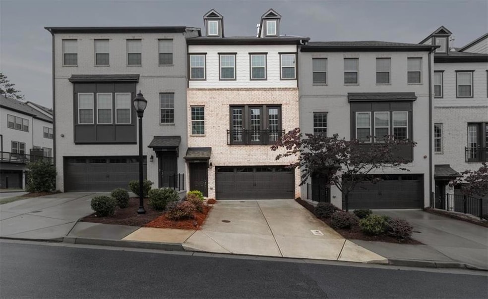 Multi unit property featuring an attached garage and concrete driveway