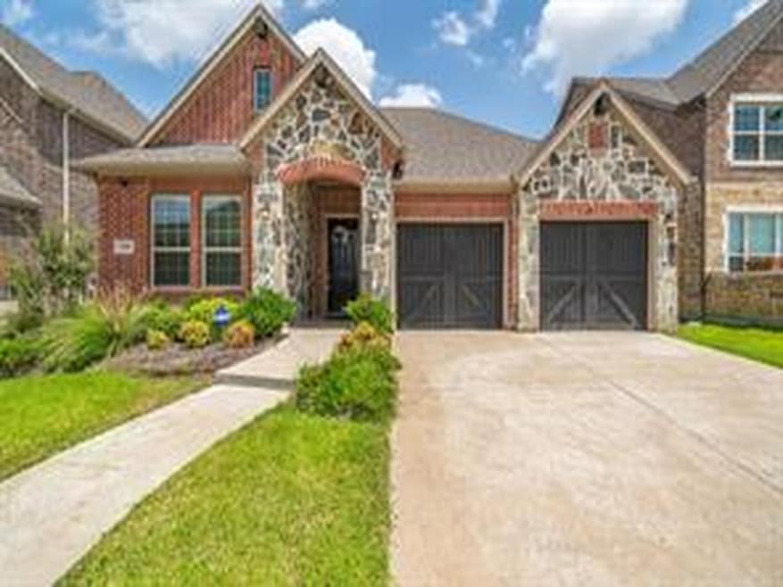 Craftsman inspired home featuring stone siding, driveway, and an attached garage
