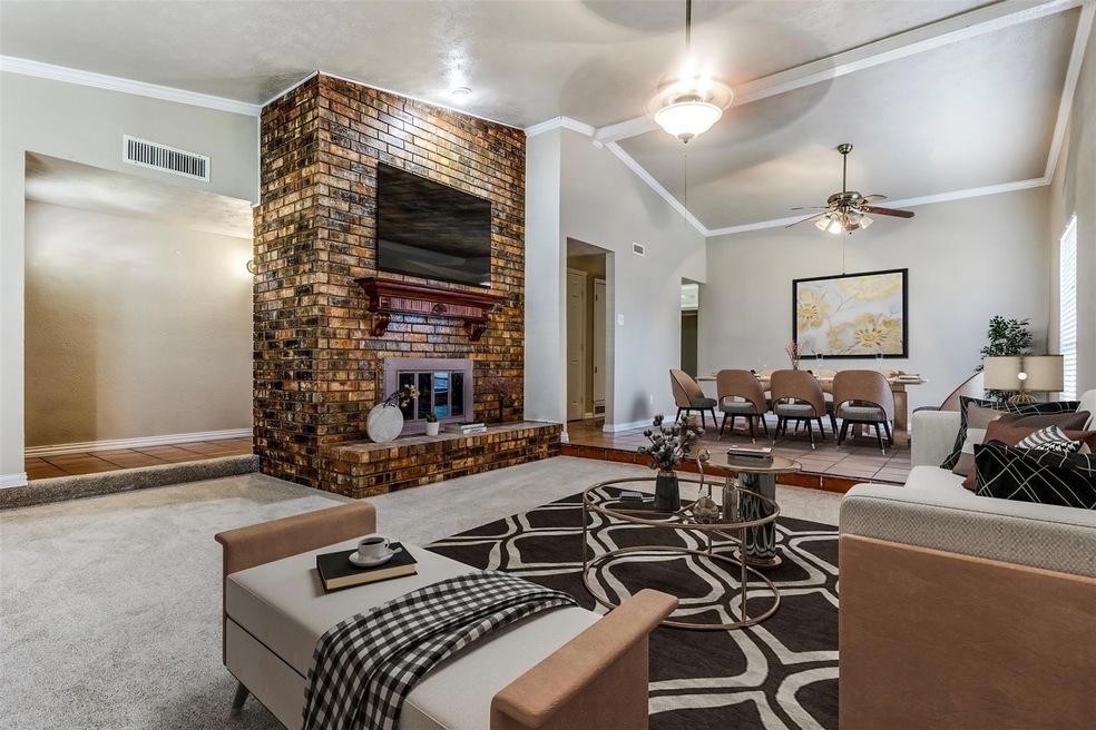 Carpeted living room featuring ceiling fan, crown 