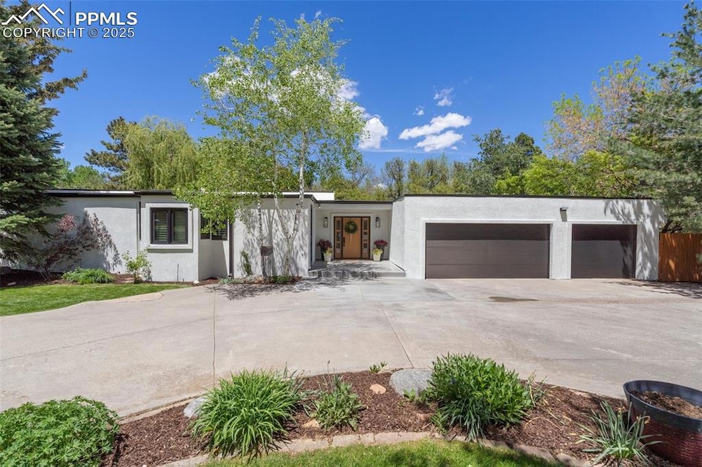 Mid-century inspired home with stucco siding, concrete driveway, and a garage