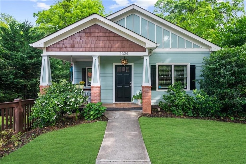 Craftsman-style house with board and batten siding, a front yard, and a porch