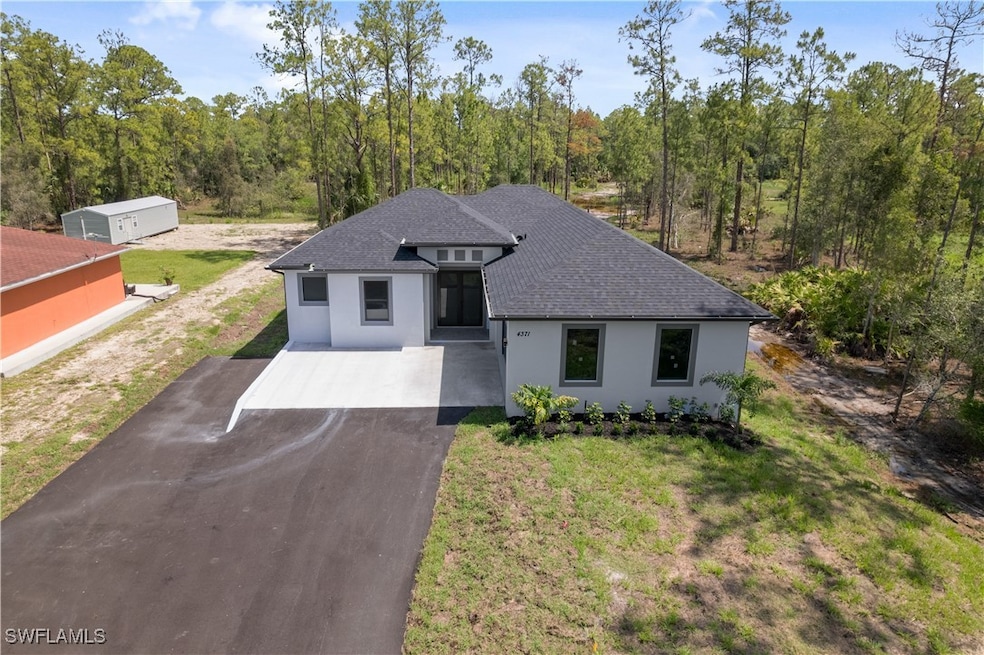 View of front of home featuring a shingled roof, d