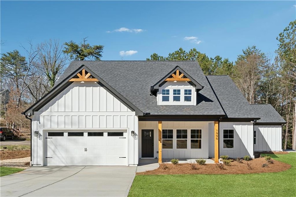 Modern farmhouse style home featuring board and batten siding, roof with shingles, concrete driveway, a garage, and a front lawn
