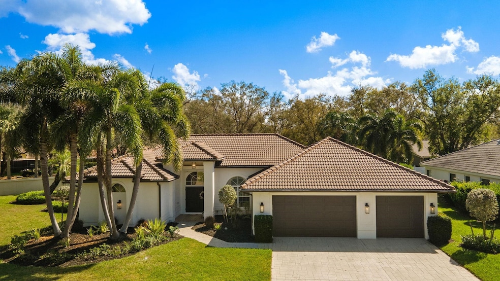 Mediterranean / spanish-style home with a front lawn, a tiled roof, driveway, stucco siding, and a garage