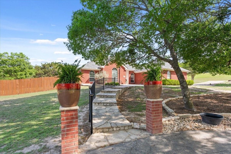 View of front of house with brick siding, fence, a