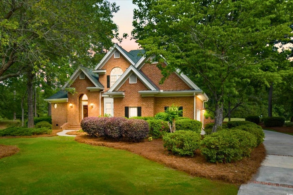 View of front of house with brick siding and a law