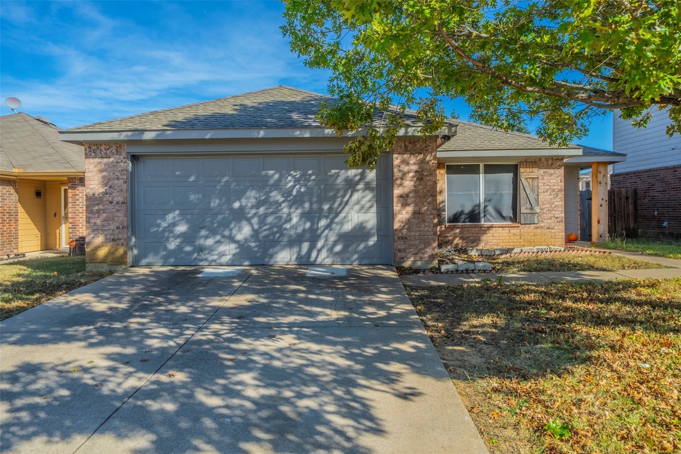 Single story home with a shingled roof, brick siding, concrete driveway, and a garage