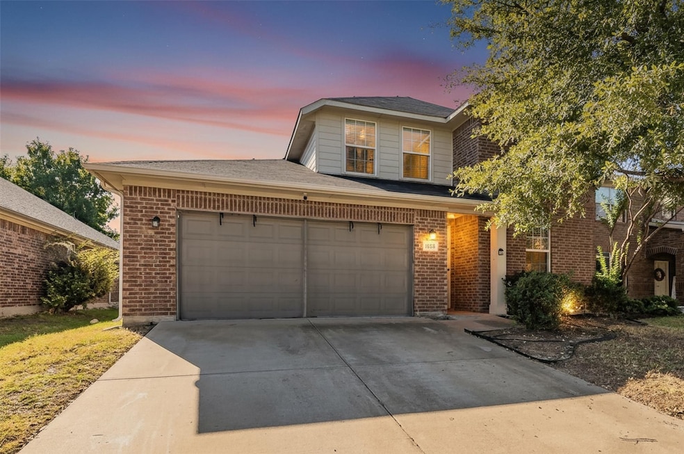 Traditional-style home with concrete driveway and brick siding