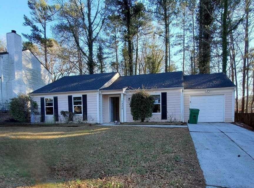 Single story home with a front lawn and a garage