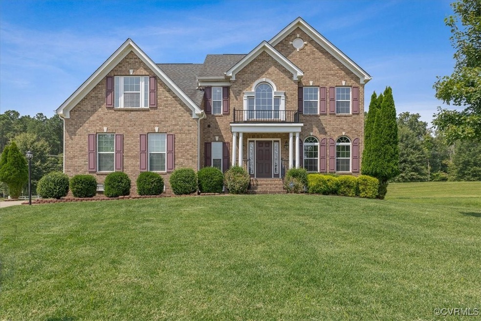 Colonial inspired home with a balcony and a front yard
