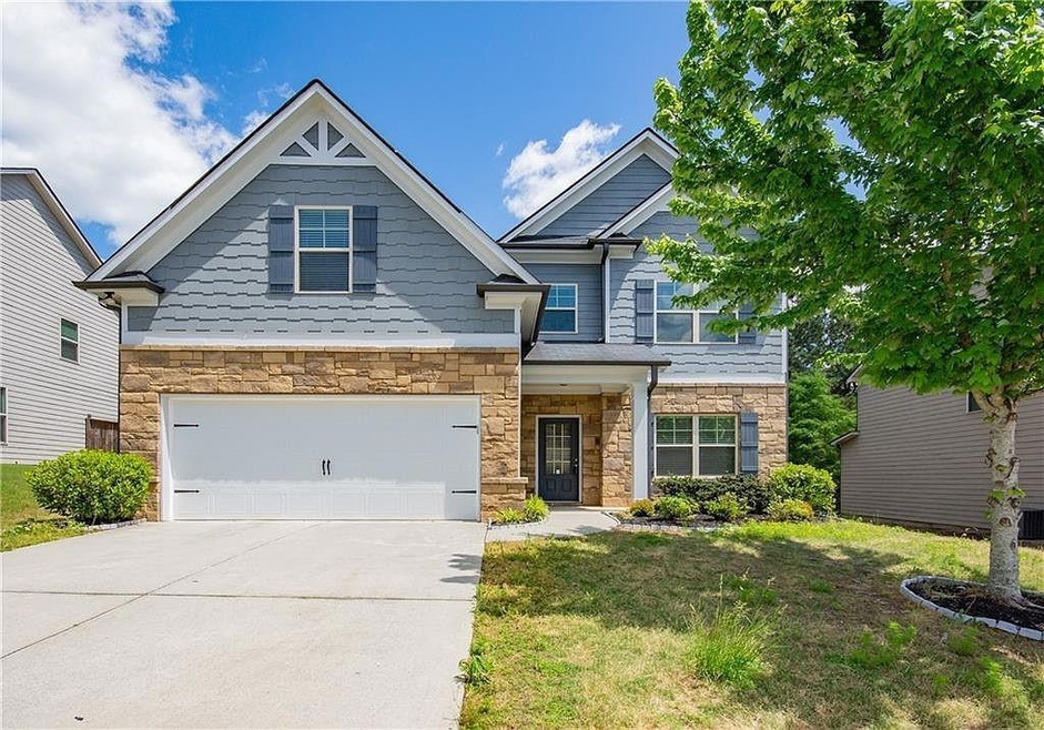 Craftsman house with a front yard and a garage