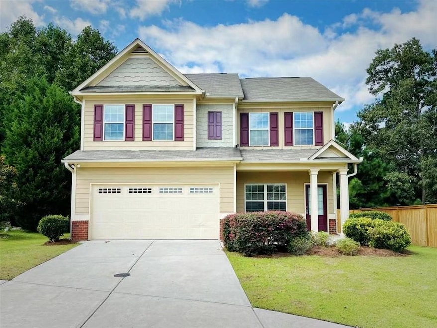 Craftsman-style house featuring an attached garage, covered porch, concrete driveway, and a shingled roof