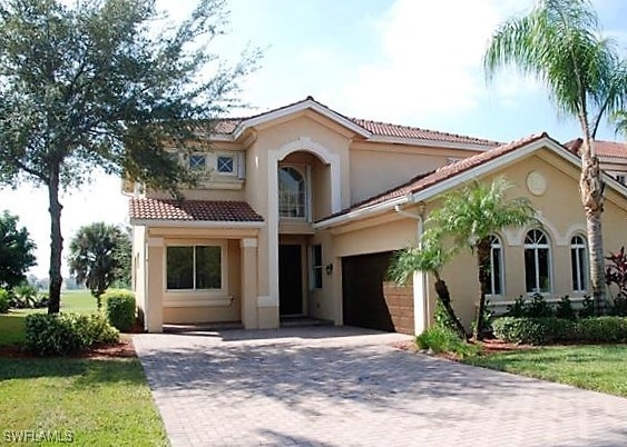Mediterranean / spanish-style home featuring decorative driveway, stucco siding, a garage, and a tile roof