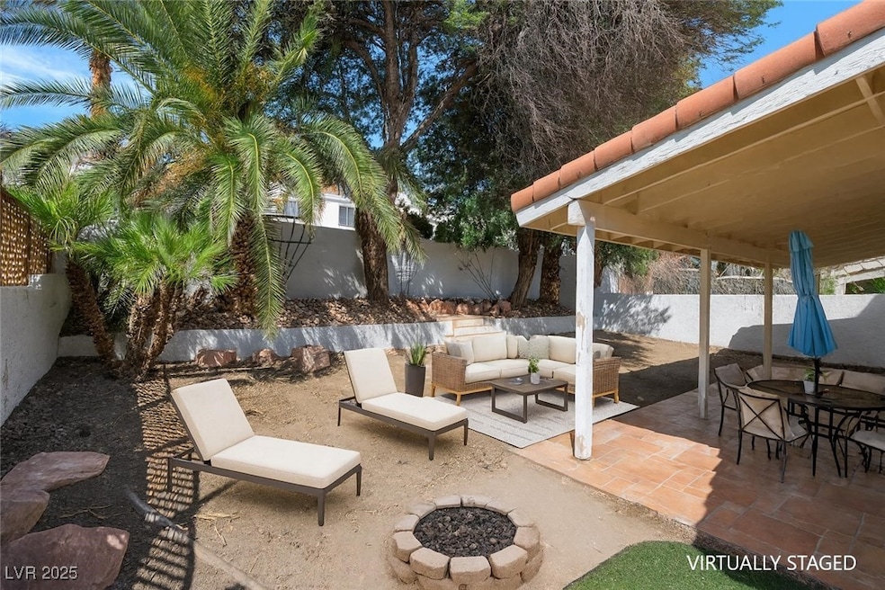 Fenced backyard with a patio, an outdoor living space with a fire pit, and outdoor dining area