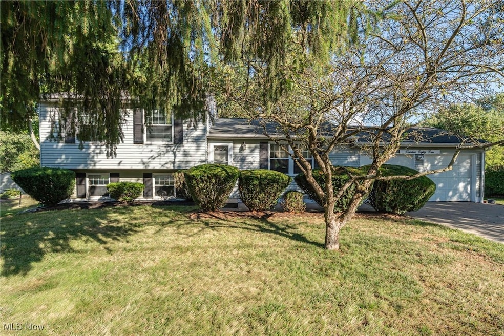 Split level home with a front yard, driveway, and an attached garage